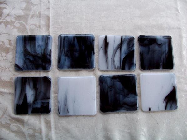 Eight CO1202 - White and Black Wispy Coasters arranged on a light fabric surface.