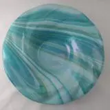 A bowl that is made of glass and has swirls.