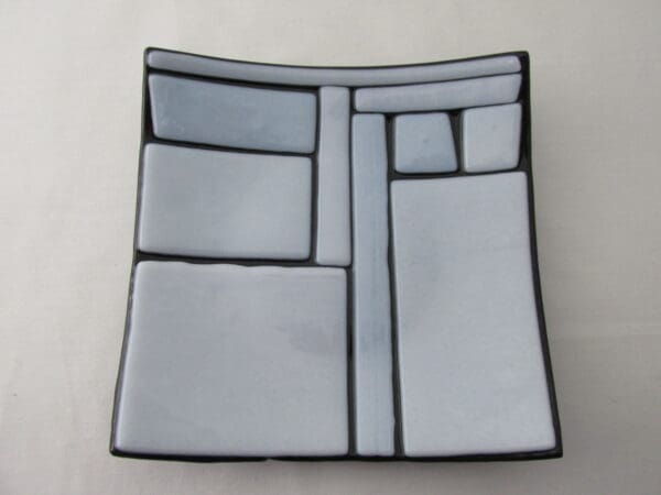 A square plate with a design of grey and black.