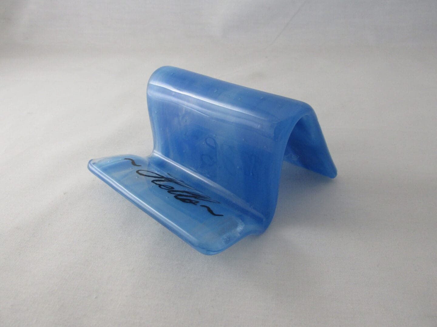 A blue plastic object with a black writing on it.