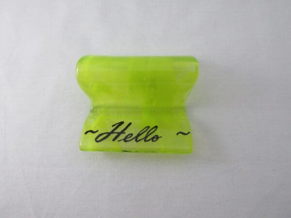 A yellow plastic object with the word hello written on it.