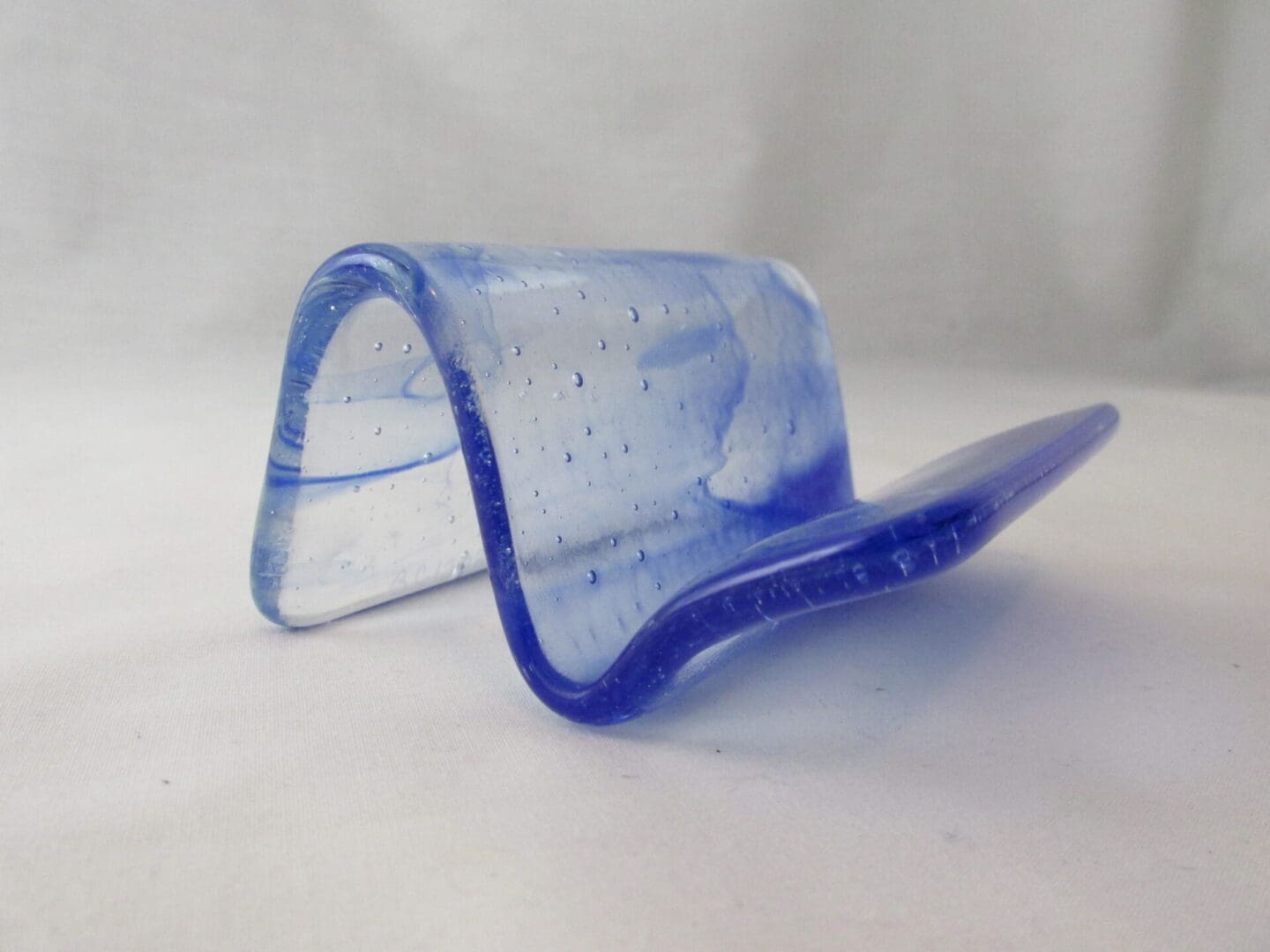 A blue glass object sitting on top of a table.