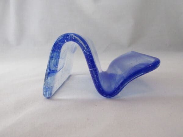 A blue glass sculpture sitting on top of a table.