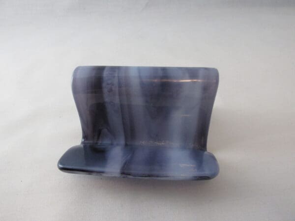 A blue and black ceramic object sitting on top of a table.