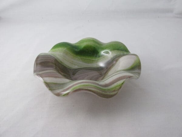 A green and white bowl sitting on top of a table.