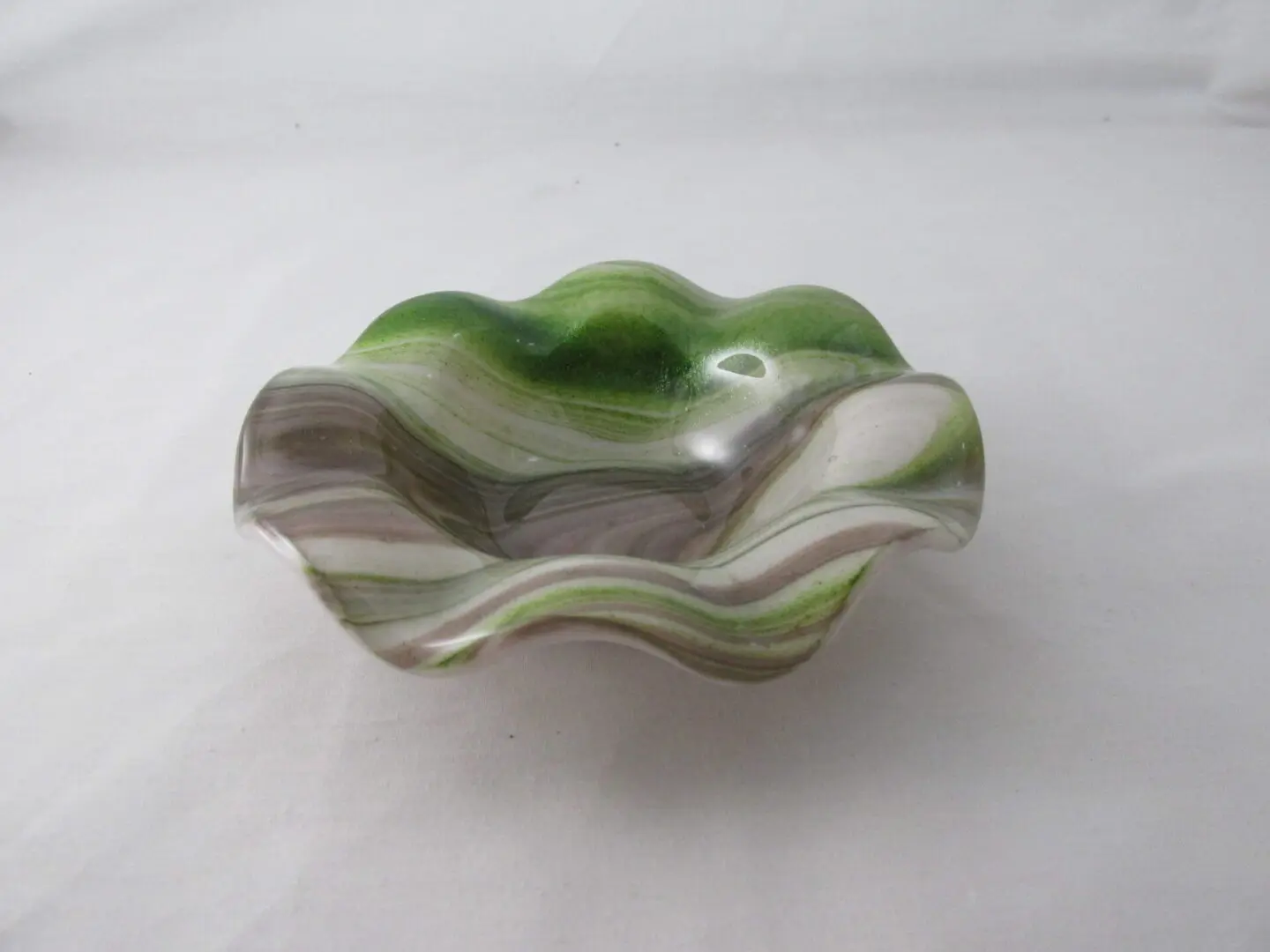 A green and white bowl sitting on top of a table.