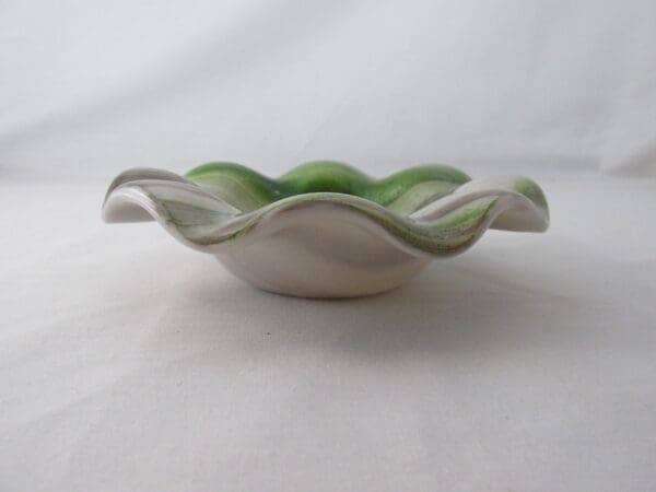 A bowl with green and white design on it.