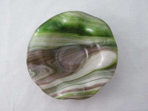 A green and brown bowl sitting on top of a table.