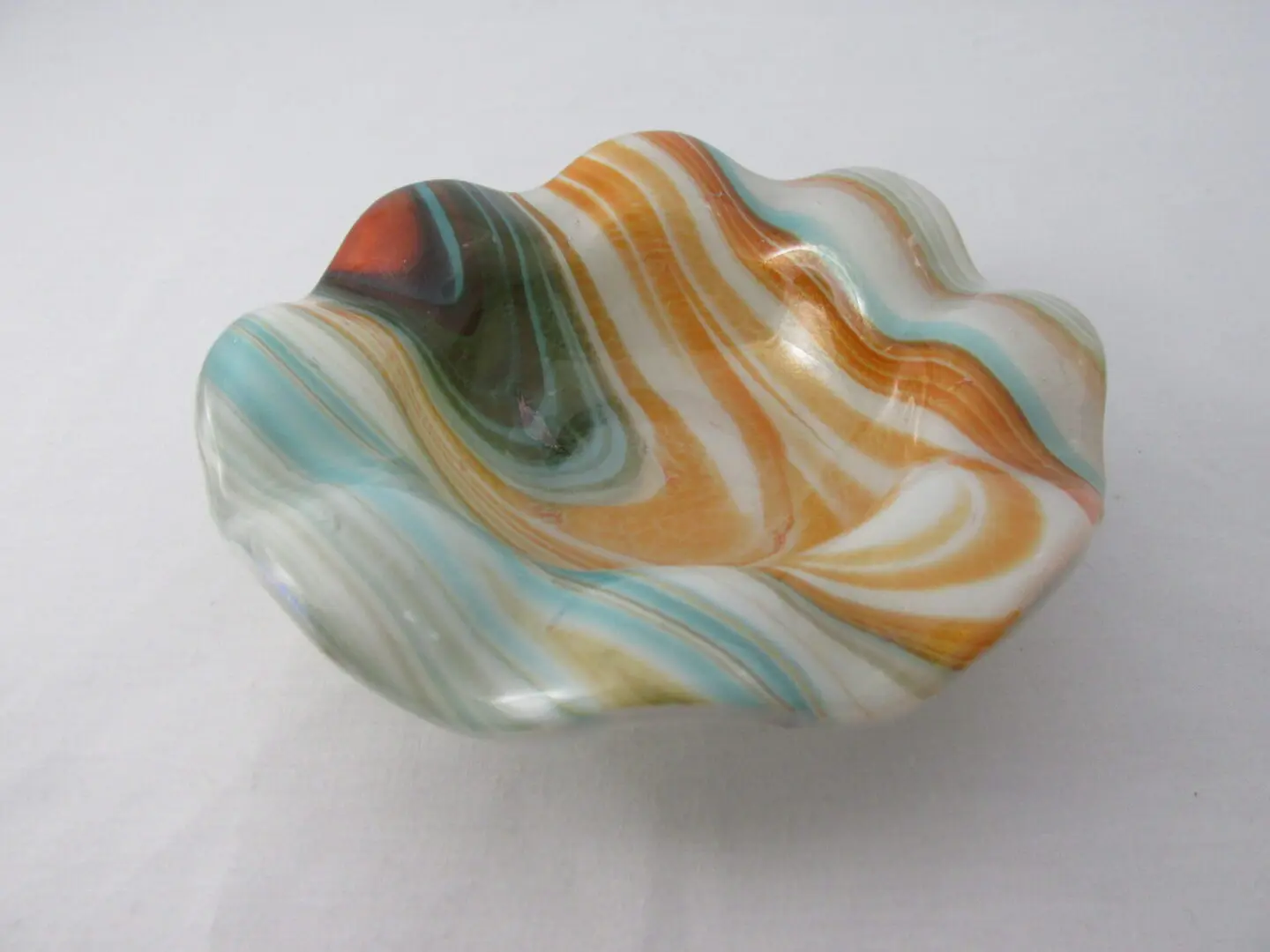 A bowl that is made of glass and has swirls.