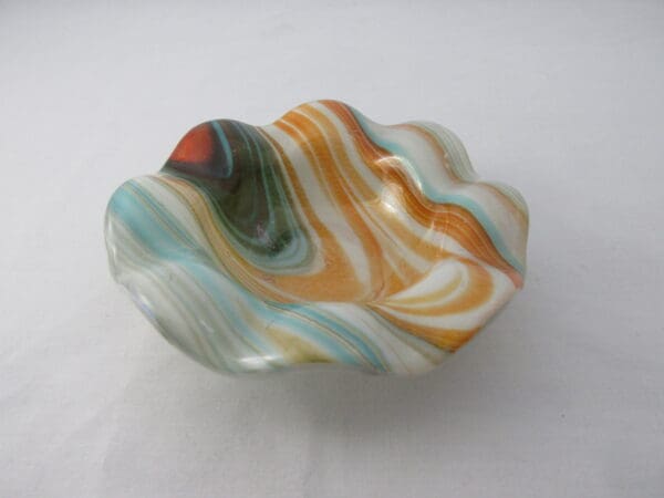 A bowl that is made of glass and has swirls.