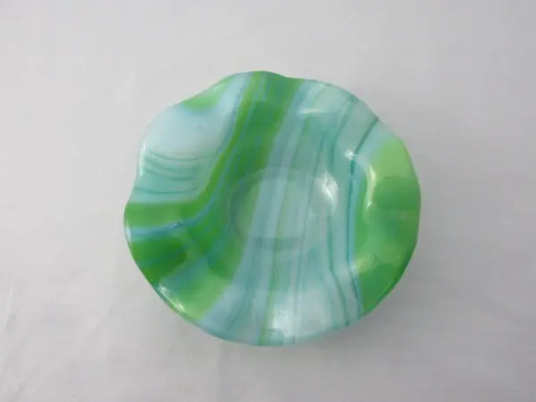 A green and white bowl sitting on top of a table.