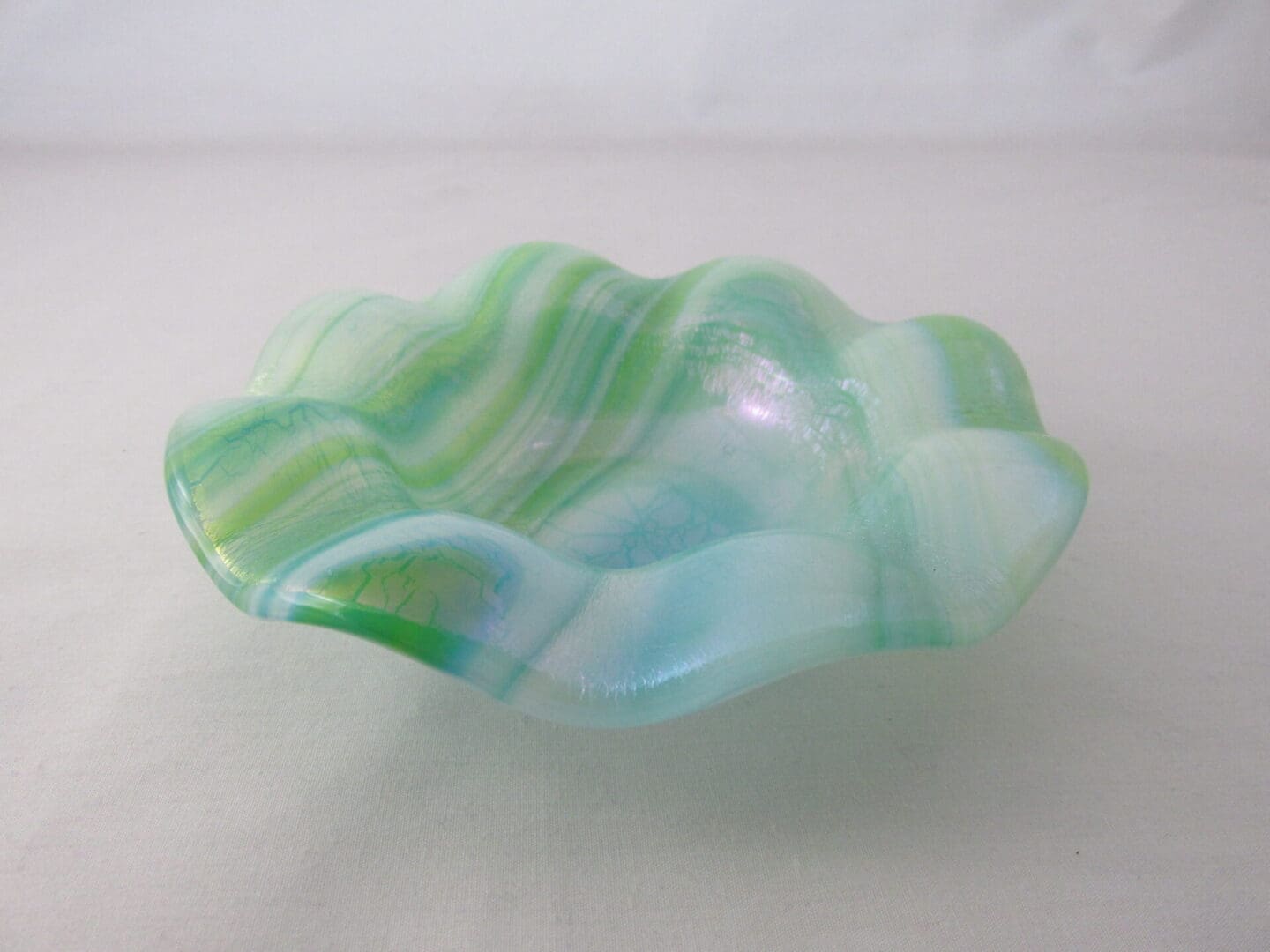 A bowl that is made of glass and has green stripes.