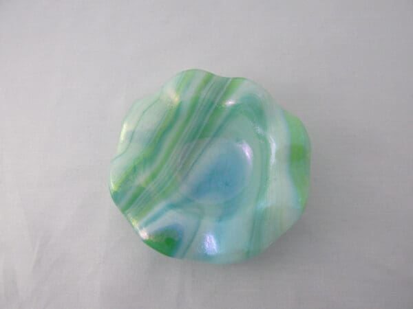 A green and blue glass bowl sitting on top of a table.