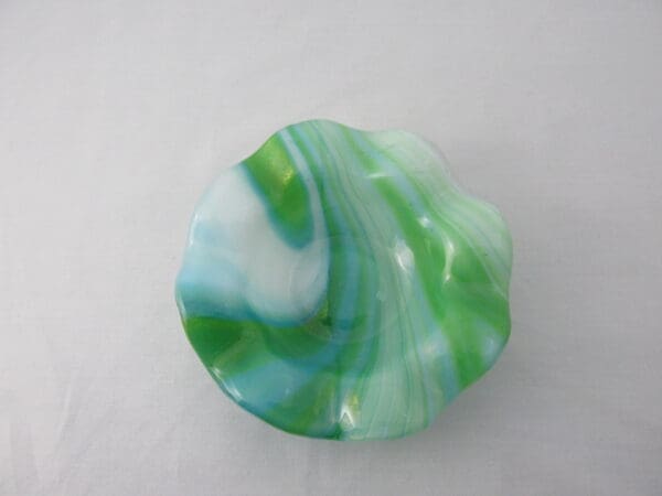 A green and white bowl sitting on top of a table.