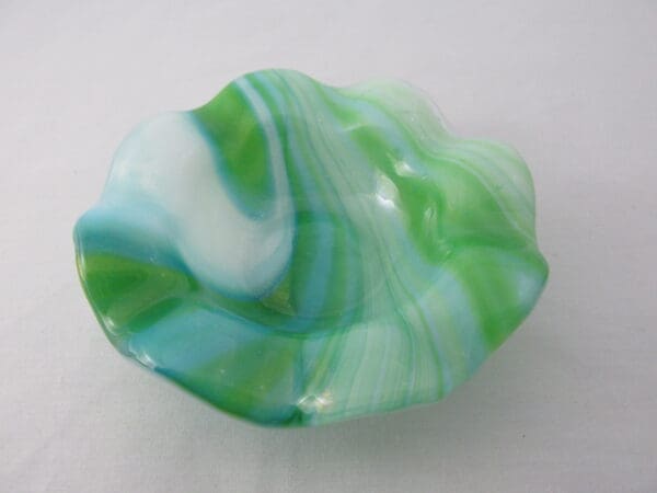 A green and white bowl sitting on top of a table.