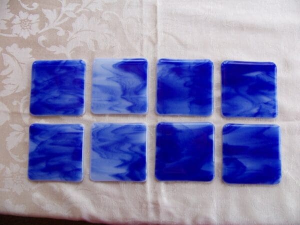 A table with eight blue glass tiles on it.