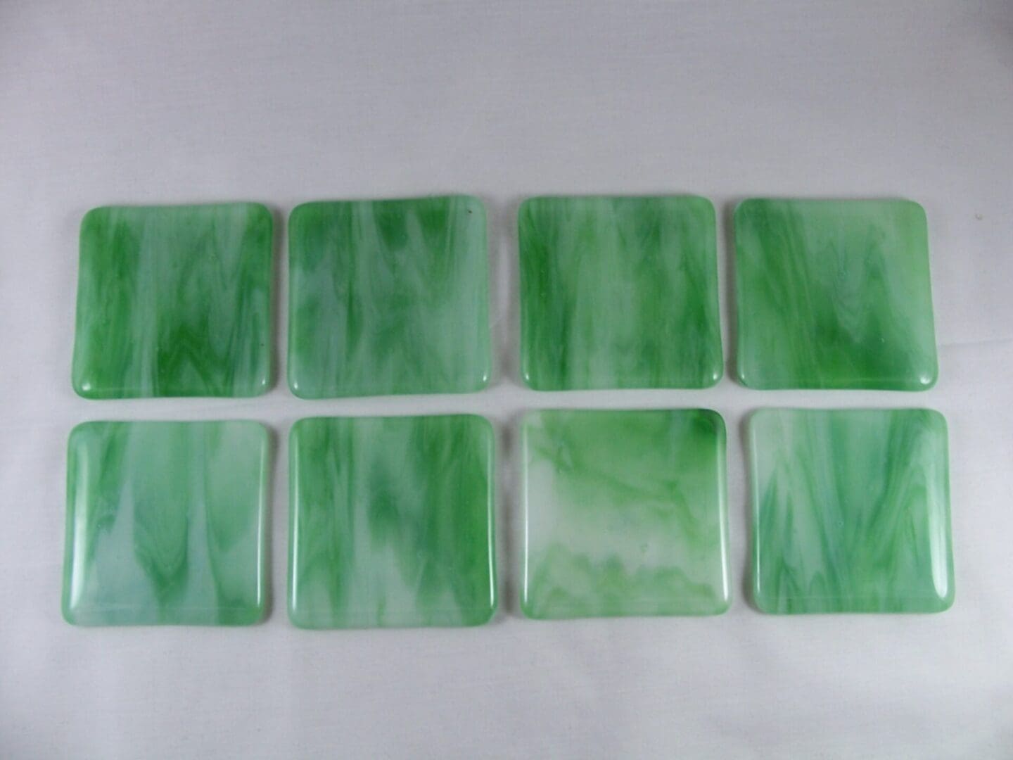 A set of eight green glass coasters.