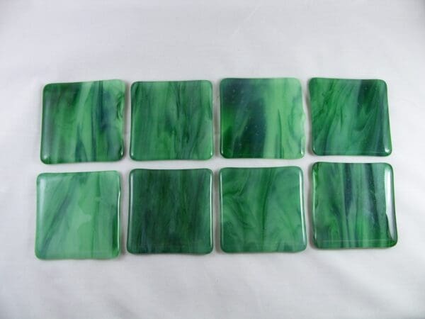 A set of eight green coasters on top of a table.