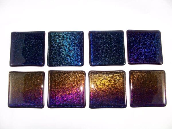 A group of eight square glass tiles in different colors.