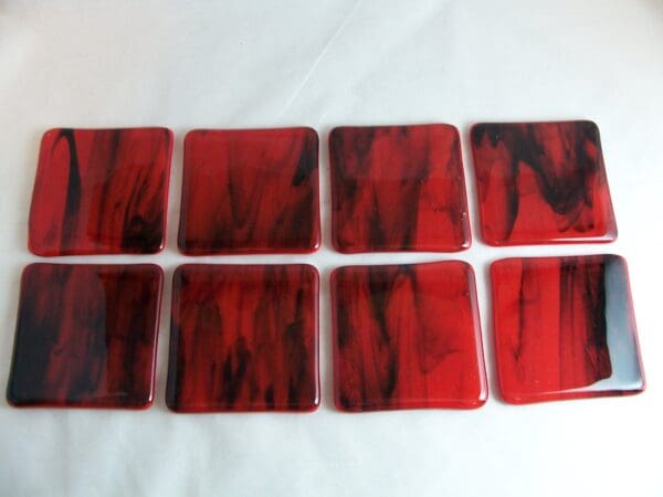 A set of eight red and black coasters.