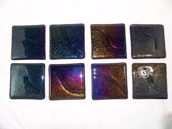 A group of eight square glass tiles in different colors.