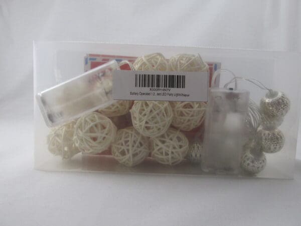 A bag of white wicker balls with a package in front.