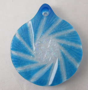 A blue and white swirl ornament on a table.