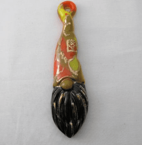 A gnome ornament is painted with yellow and orange.