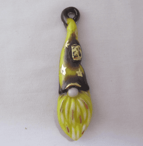 A yellow and black ceramic object hanging on a white wall.