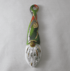 A green and white spoon with a bird on it.