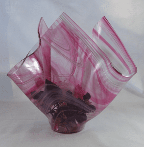 A pink vase with some sort of purple substance inside it