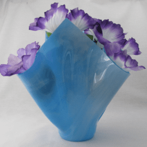 A blue vase with purple flowers in it.