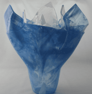 A blue paper bag with some flowers inside of it