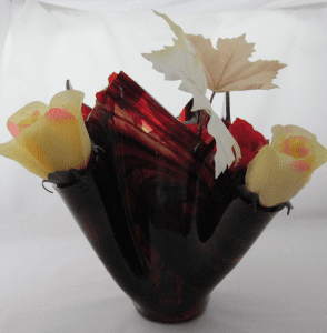 A vase with flowers and leaves in it.