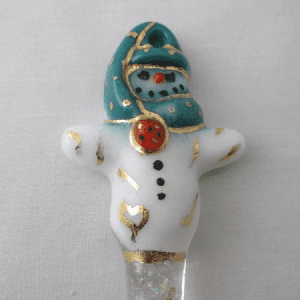 A white and blue snowman ornament with gold accents.