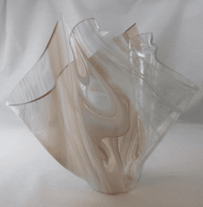 A glass vase with some brown and white swirls