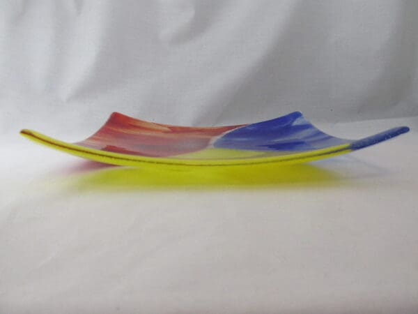 A colorful glass plate sitting on top of a table.