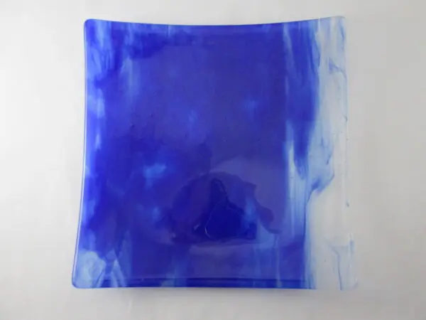 A blue square plate with some white on it