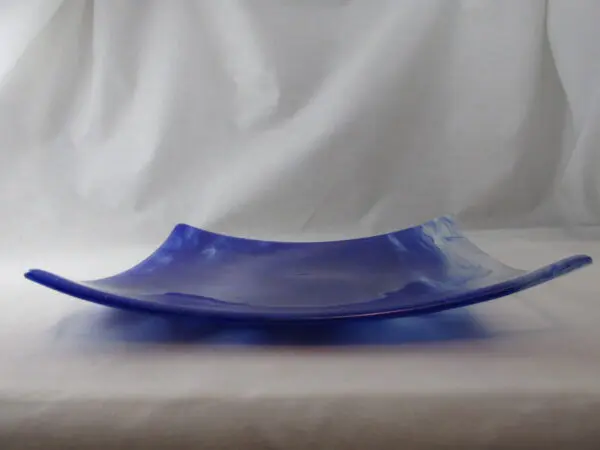 A blue glass plate sitting on top of a table.