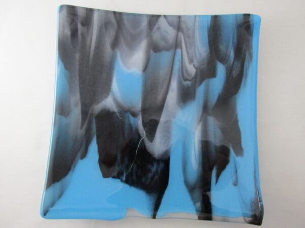 A blue and black painting on glass