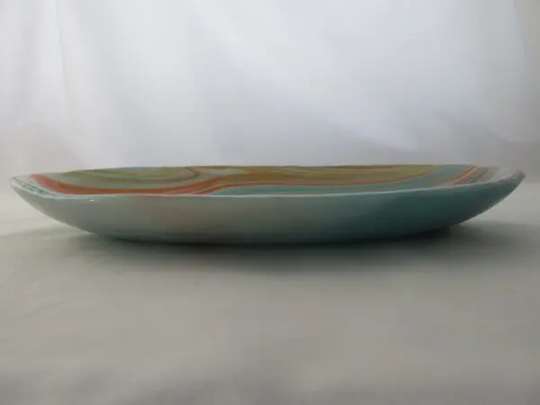 A green plate with orange and white stripes on it