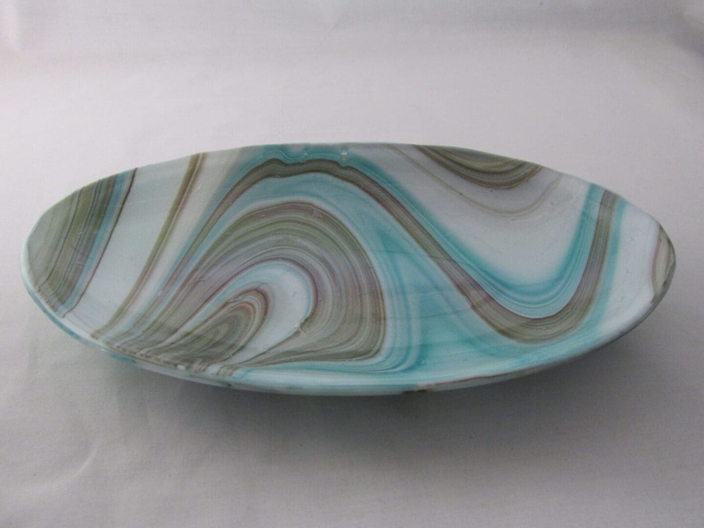 A glass bowl with swirling blue and brown designs.