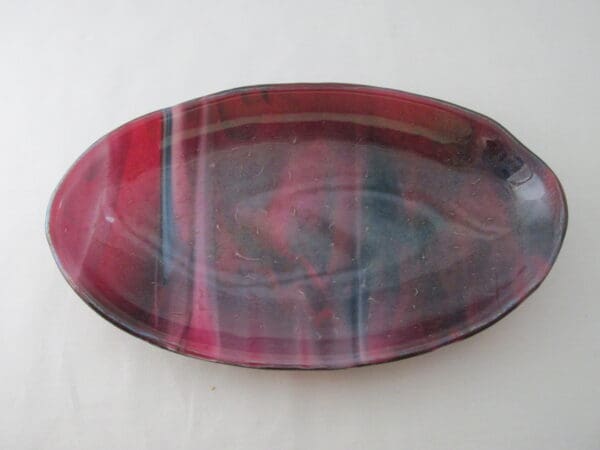 A red and black plate on top of a table.