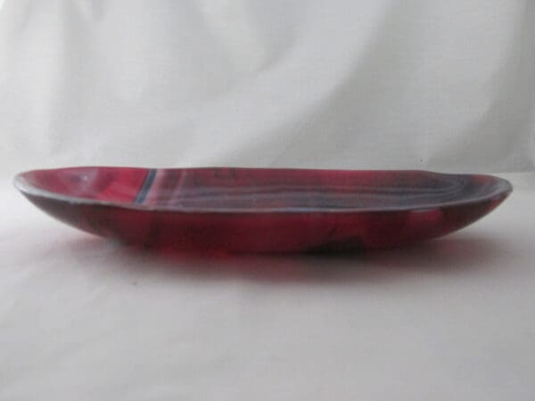 A red glass dish sitting on top of a table.