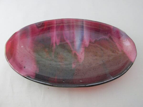 A red and black bowl sitting on top of a table.