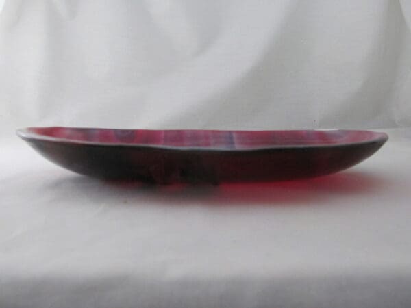 A red glass plate sitting on top of a table.