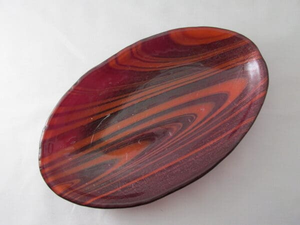 A red and black bowl on top of a table.