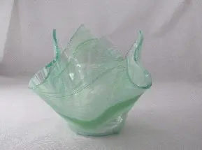 A green glass bowl sitting on top of a table.