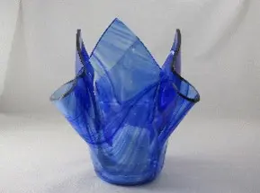 A blue glass vase with a pattern of folded up squares.