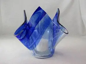 A blue glass vase with two handles on top of it.